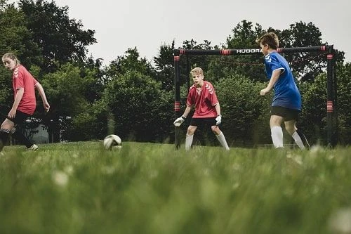 Portë futbolli Hudora Pro Tect 240, 240x160x85 cm, me mbrojtje shkumë EPE, rrjetë poliester, 6 kunja ankore, e zezë