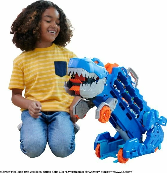 Set garazh/transportues dinosauri Mattel Hot Wheels City T-Rex Mega Transporter HNG50, me drita e tinguj, ruan 20+ vetura, me 2 vetura 1:64, blu/portokalli