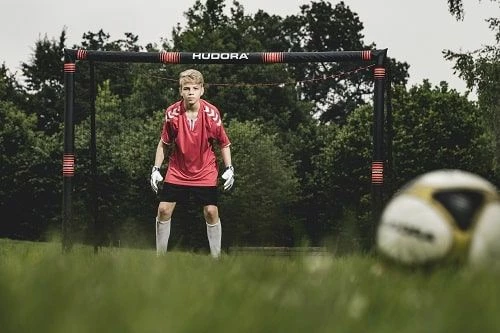 Portë futbolli Hudora Pro Tect 240, 240x160x85 cm, me mbrojtje shkumë EPE, rrjetë poliester, 6 kunja ankore, e zezë