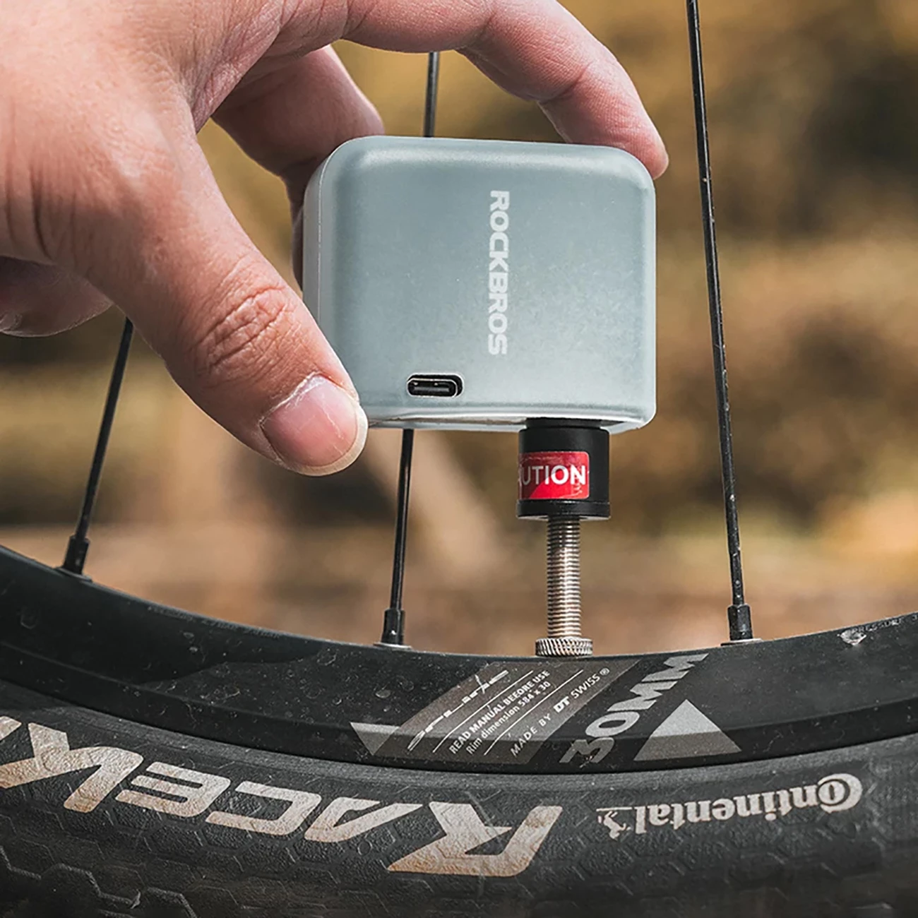 Pompë elektrike mini për biçikletë Rockbros 42320008001, 100 PSI (6.9 bar), Presta/Schrader, 300 mAh, USB-C, me dritë LED, Set me këllëf silikoni + majë Presta + unazë vulosëse + kabllo USB-C–USB-A, e zezë